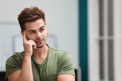 Photo of Portrait of handsome young man in room. Space for text