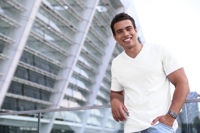 Handsome young African-American man on city street. Space for text