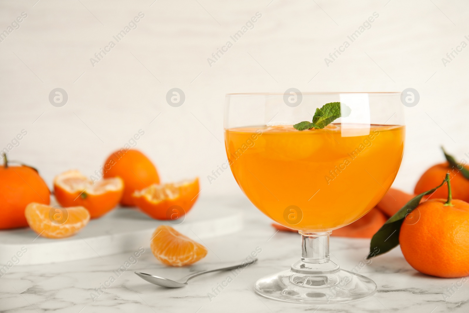 Photo of Delicious tangerine jelly on white marble table