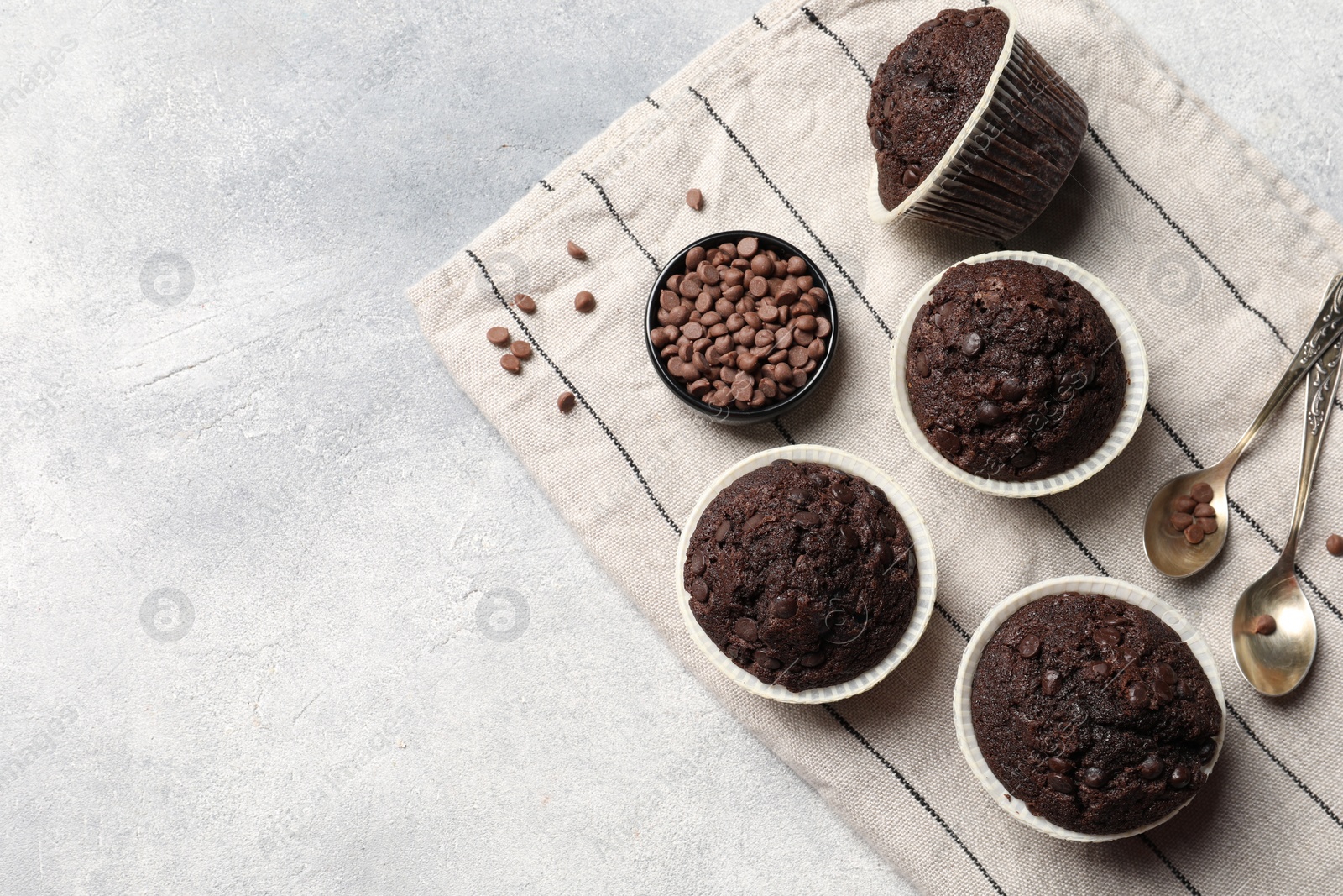 Photo of Tasty chocolate muffins on grey table, top view. Space for text