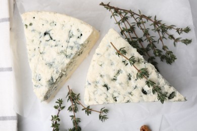 Photo of Tasty blue cheese with thyme on table, top view