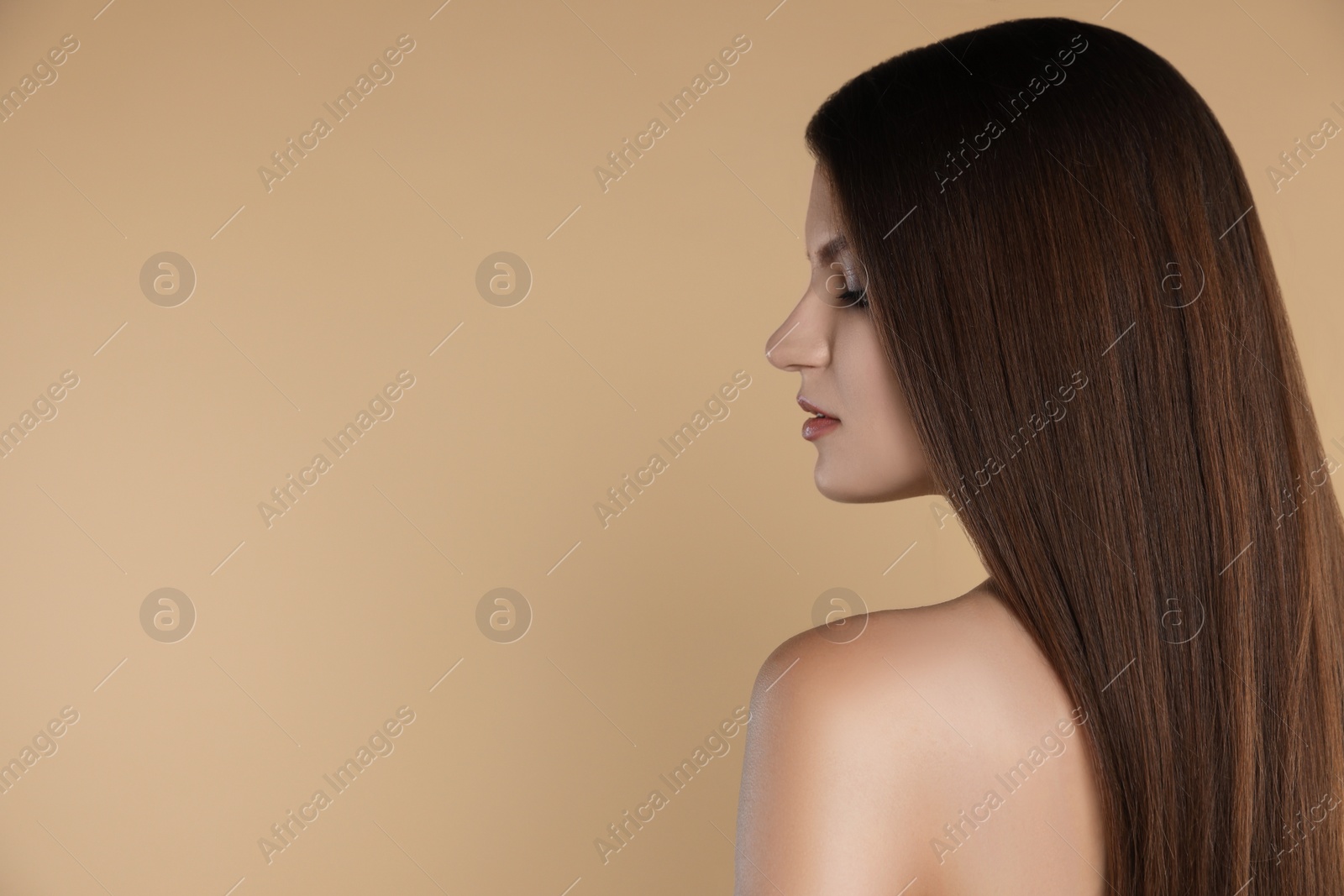 Photo of Young woman with strong healthy hair on beige background, space for text