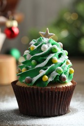 Photo of Christmas tree shaped cupcake on table, closeup