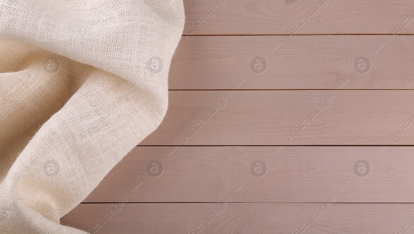 Photo of Beige burlap fabric on wooden table, top view. Space for text