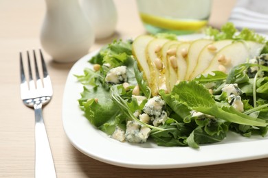 Photo of Fresh salad with pear served on wooden table