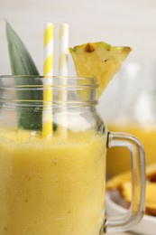 Photo of Tasty pineapple smoothie on blurred background, closeup