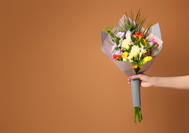 Photo of Woman with beautiful bouquet of freesia flowers on color background