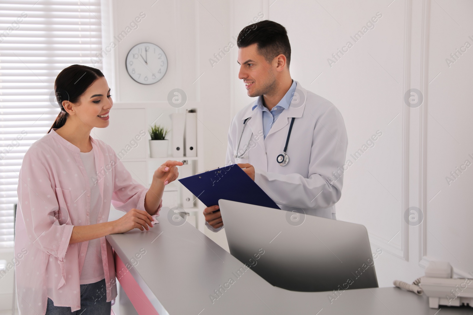 Photo of Doctor working with patient at reception in hospital