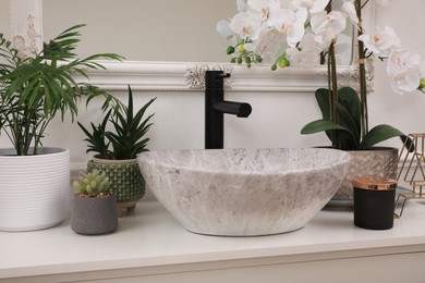 Photo of Stylish sink and beautiful houseplants in bathroom. Interior design