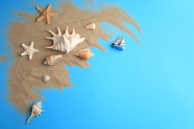 Photo of Flat lay composition with beautiful starfishes and sand on blue background. Space for text