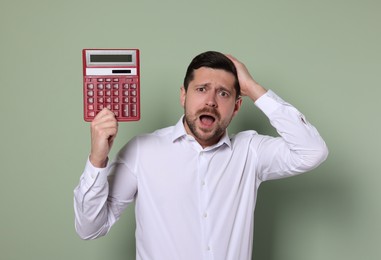 Photo of Emotional accountant with calculator on olive background
