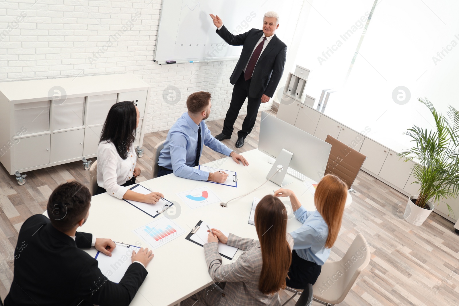 Photo of Senior business trainer working with people in office