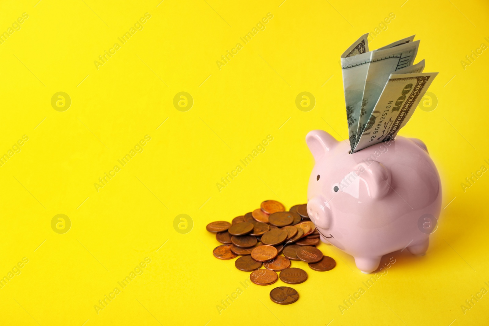 Photo of Cute piggy bank with banknotes and coins on color background. Space for text