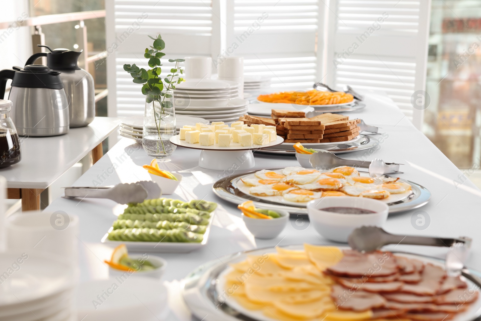 Photo of Different meals for breakfast on white table indoors. Buffet service