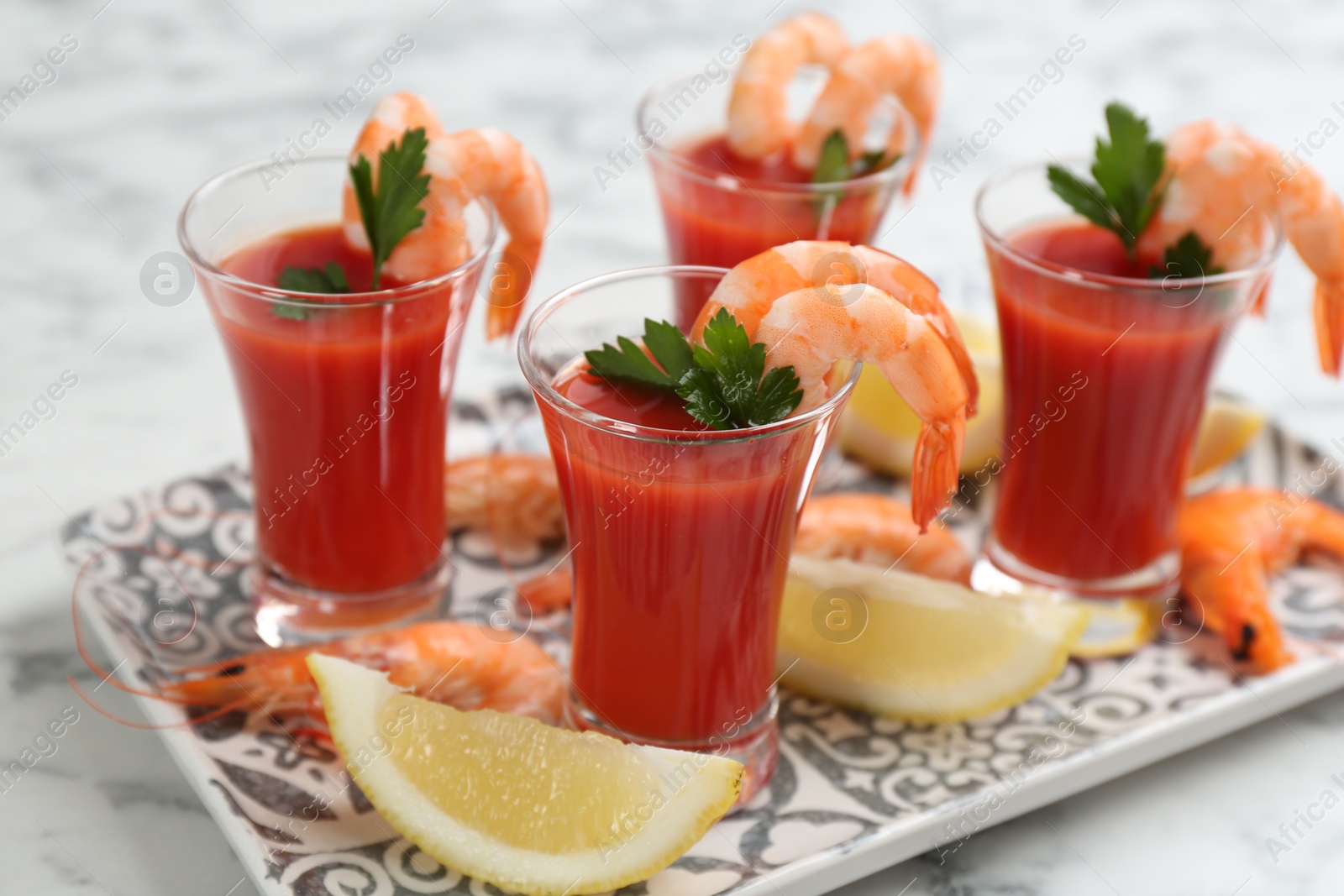 Photo of Shrimp cocktail with tomato sauce served on marble table