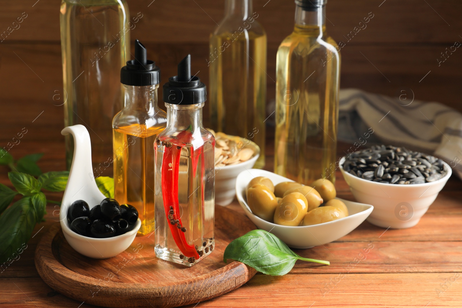 Photo of Different cooking oils and ingredients on wooden table