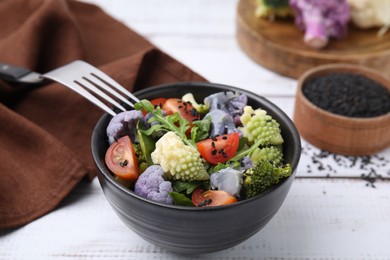 Delicious salad with cauliflower and tomato served on white wooden table, closeup