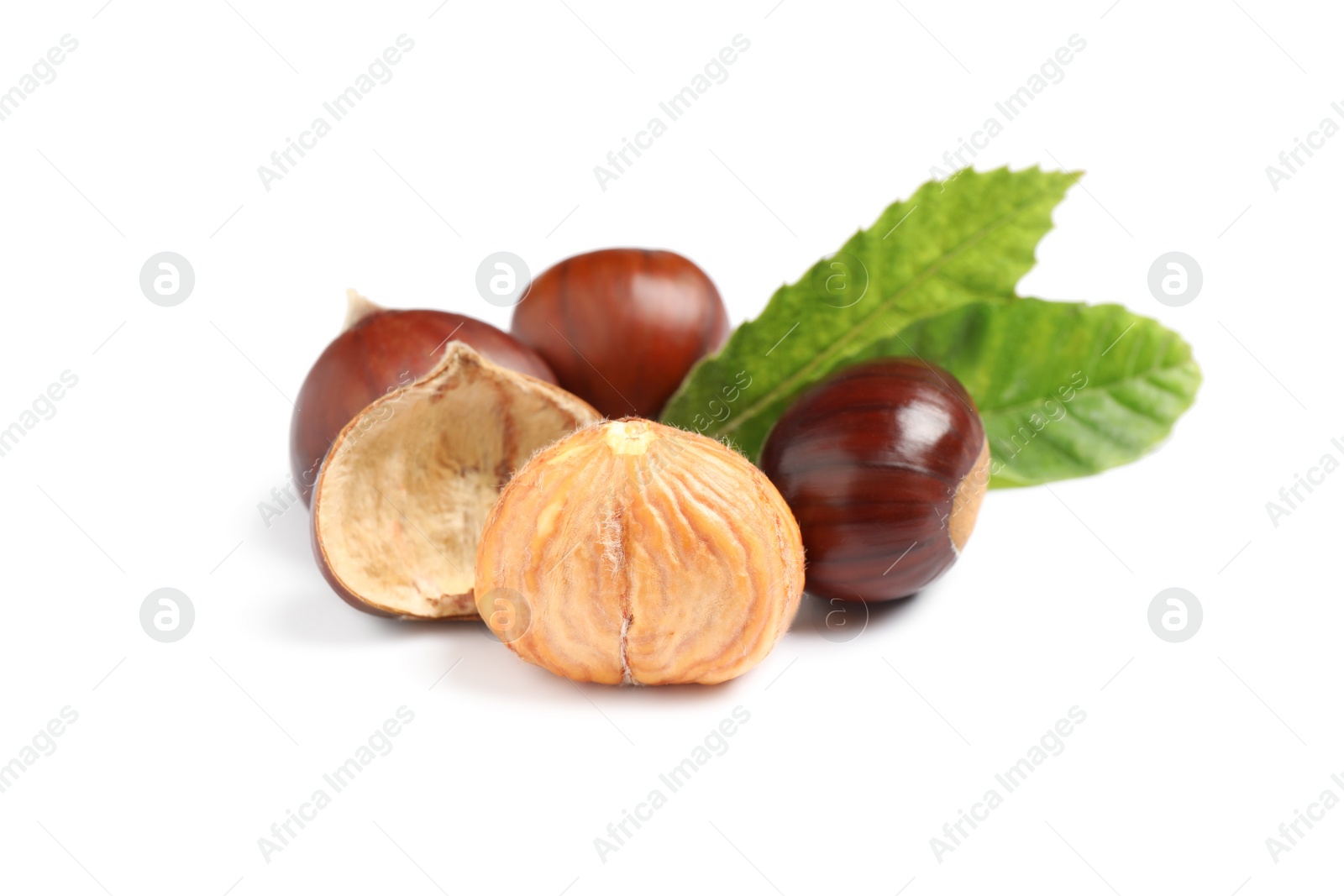 Photo of Fresh sweet edible chestnuts with green leaves on white background