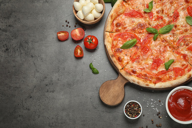 Delicious pizza Margherita and ingredients on grey table, flat lay. Space for text