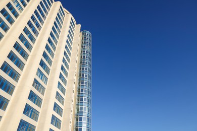 Photo of Beautiful skyscraper against blue sky on sunny day, low angle view