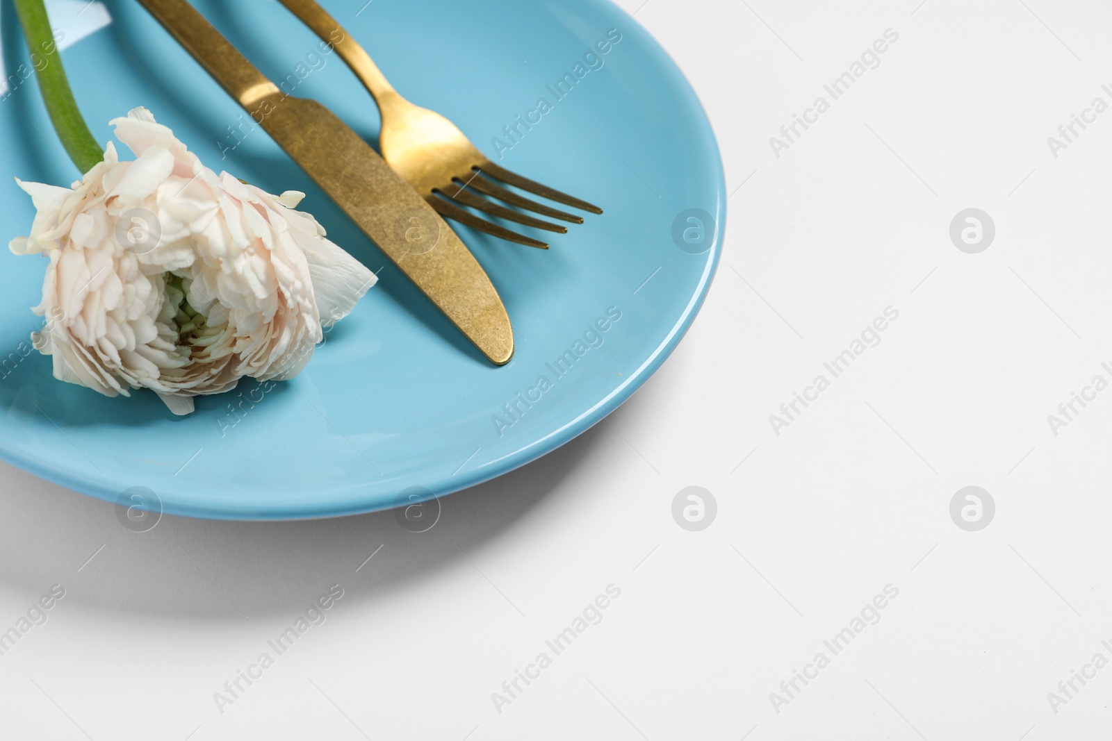 Photo of Stylish table setting with cutlery and flower on white background, closeup. Space for text