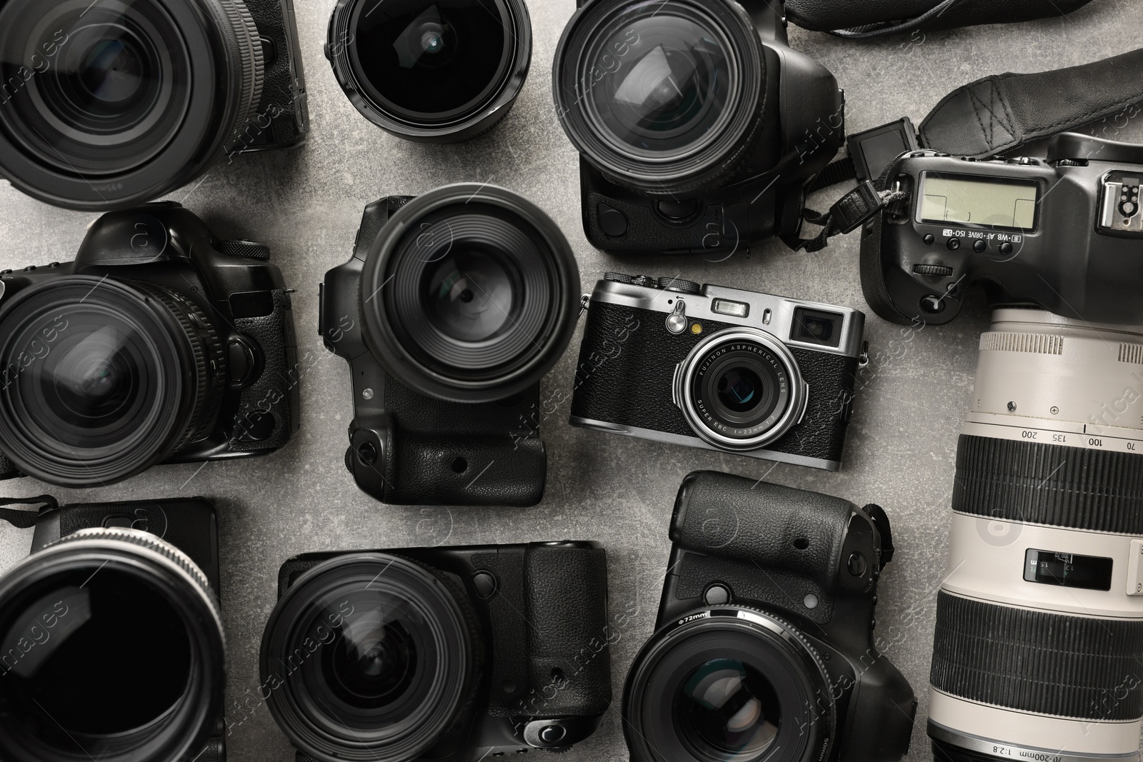 Photo of Modern cameras on gray textured table, flat lay