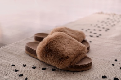 Photo of Pair of soft slippers on floor in room