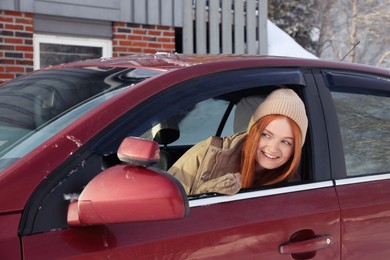 Photo of Happy young woman looking out of car window. Winter vacation