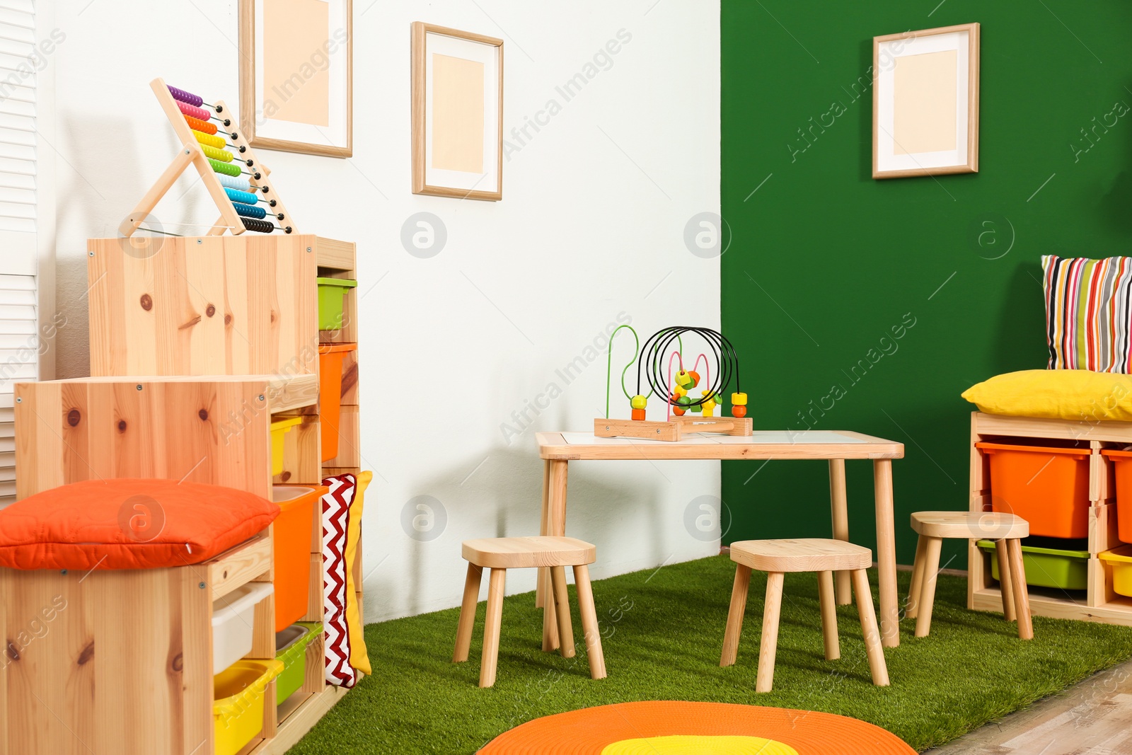 Photo of Stylish playroom interior with table and stools