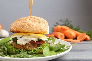 Photo of Delicious vegetarian burger served on grey wooden table