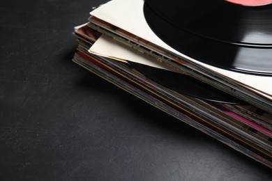 Photo of Stack of vintage vinyl records on black background, closeup. Space for text