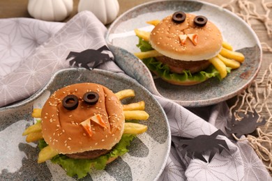 Photo of Tasty monster sandwiches and Halloween decorations on table, closeup