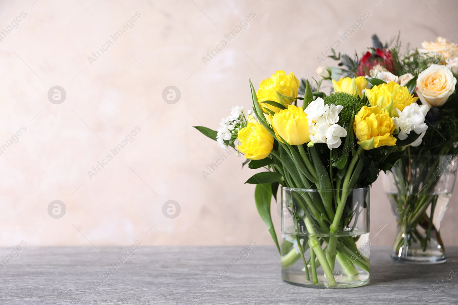 Photo of Beautiful bouquets with fresh flowers on grey table, space for text