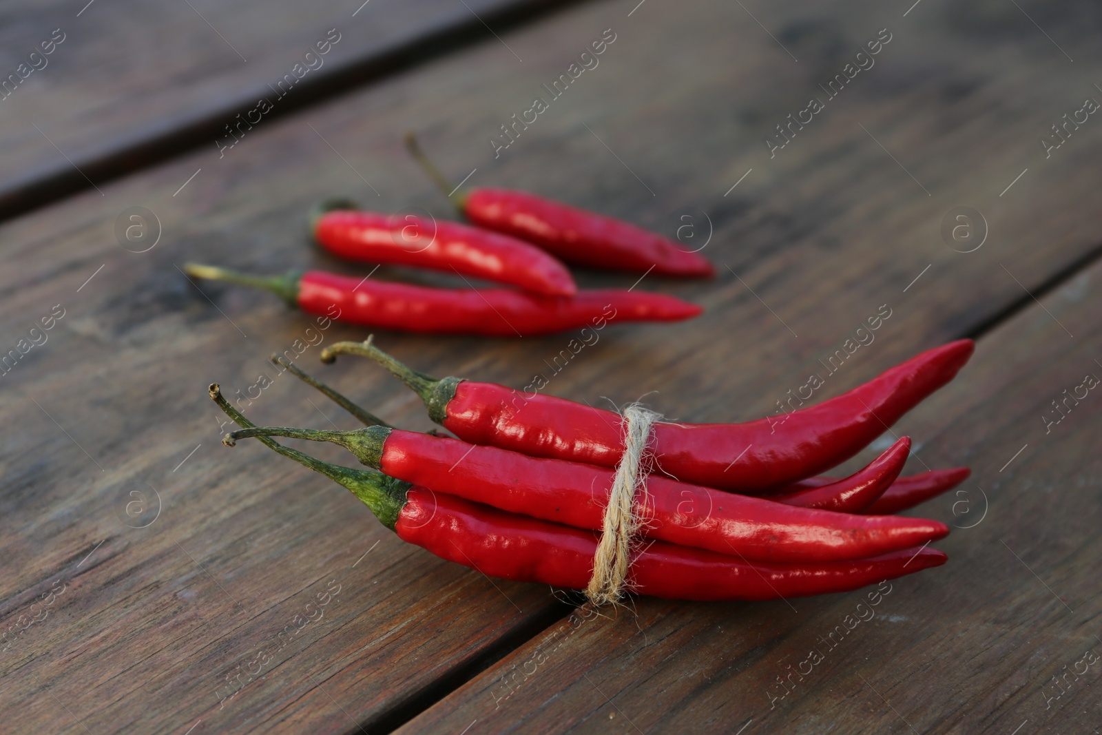 Photo of Fresh ripe chili peppers on wooden table