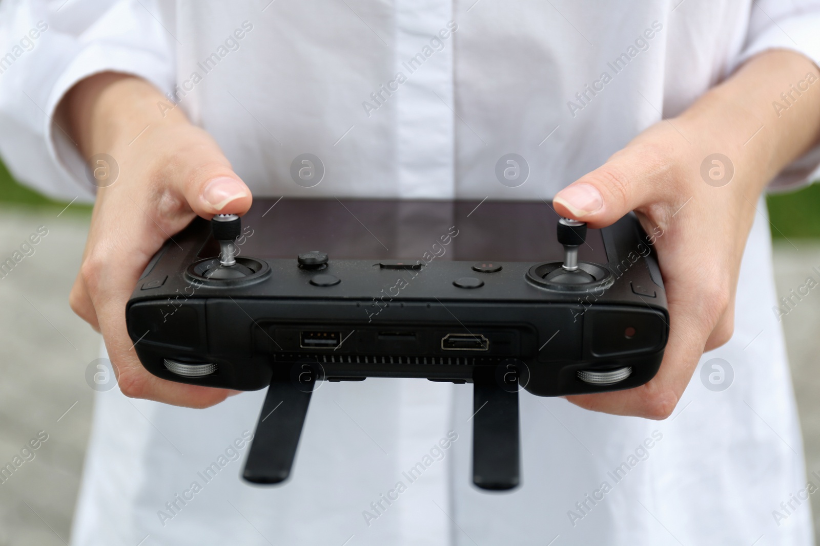 Photo of Woman with modern drone controller outdoors, closeup