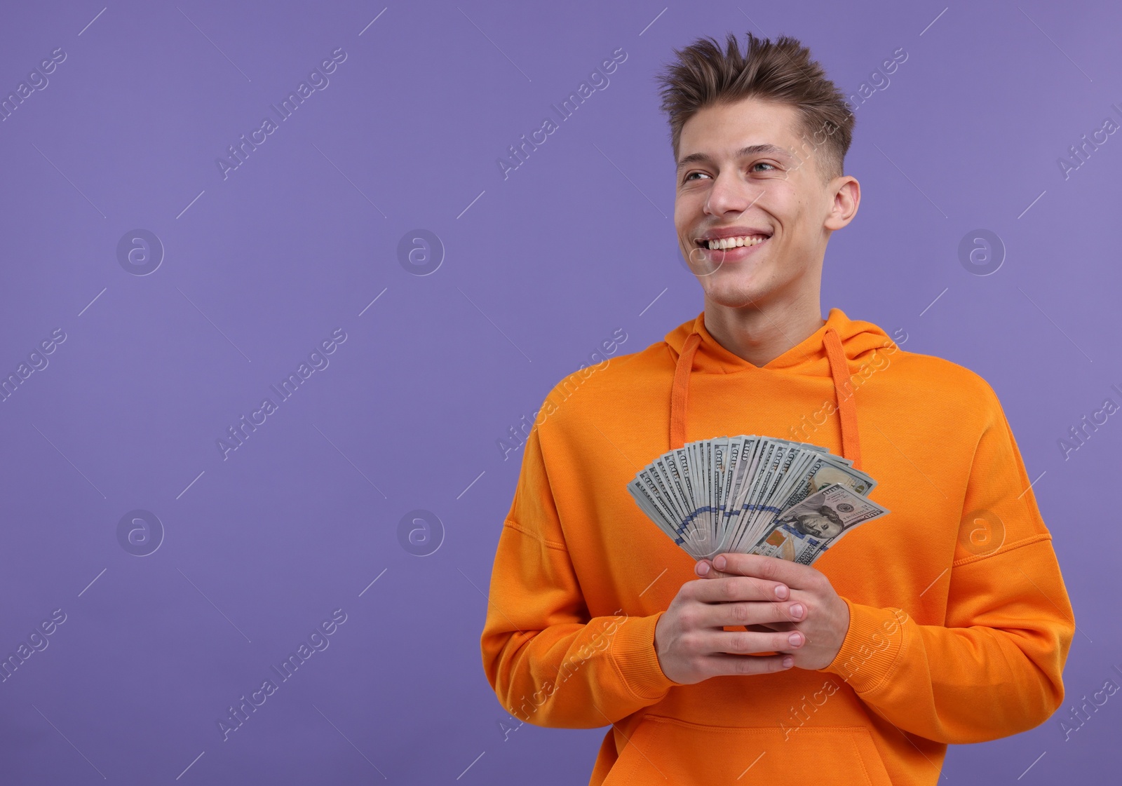 Photo of Happy man with money on purple background. Space for text