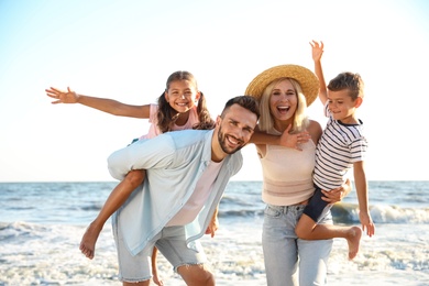 Photo of Happy family on beach near sea. Summer vacation