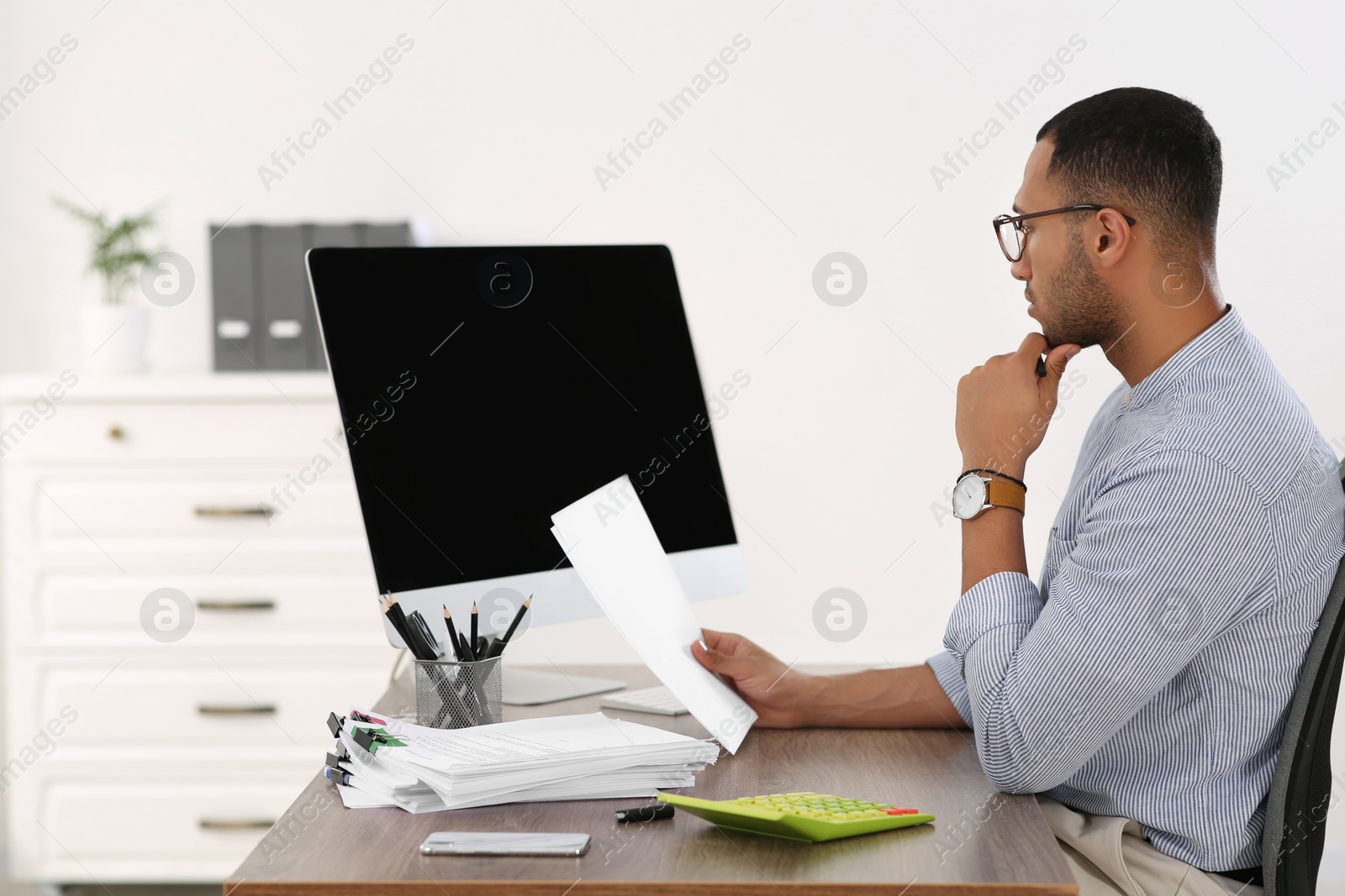 Photo of Businessman working with documents at wooden table in office