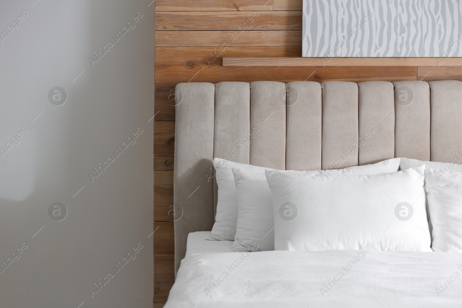 Photo of Bed with soft pillows in room. Modern interior