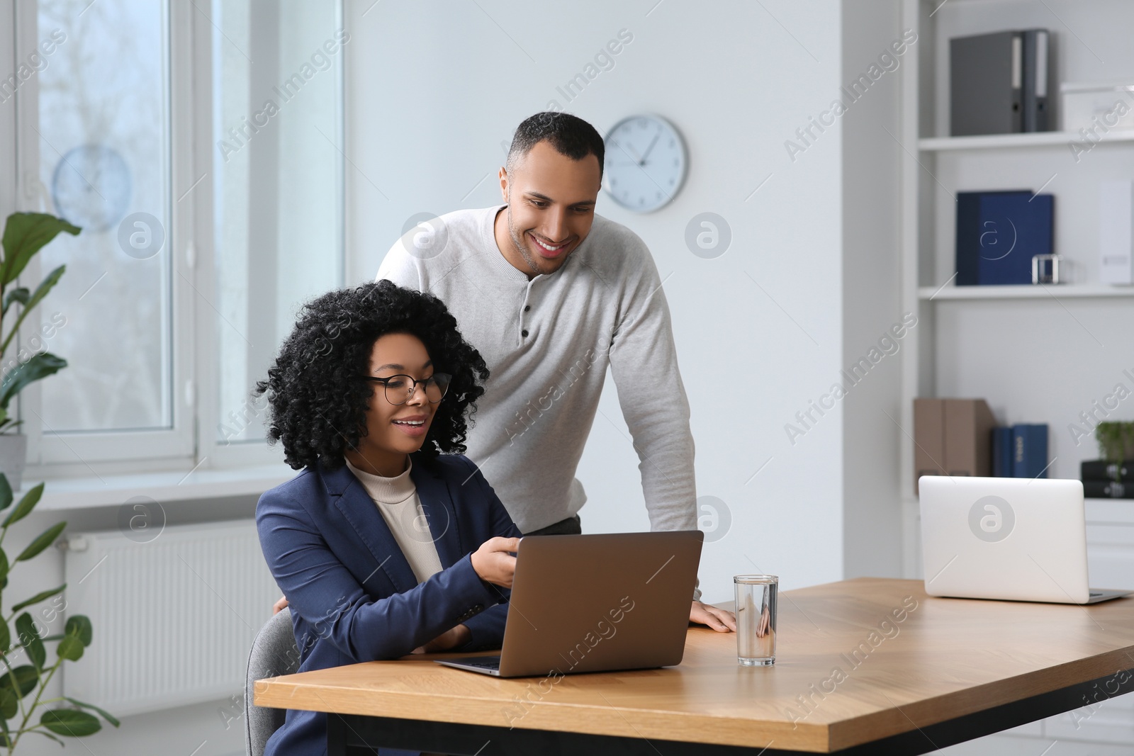 Photo of Young colleagues working together at table in office