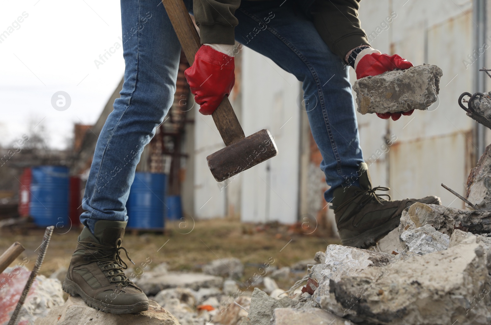 Photo of Man with sledgehammer and stone outdoors, closeup