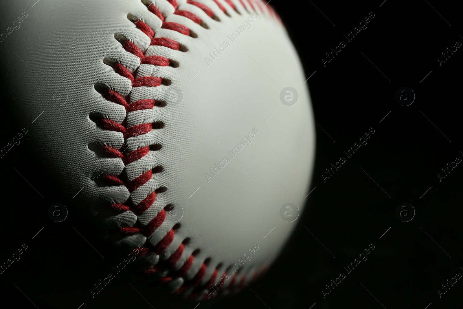 Photo of Baseball ball on black background, closeup with space for text. Sports game