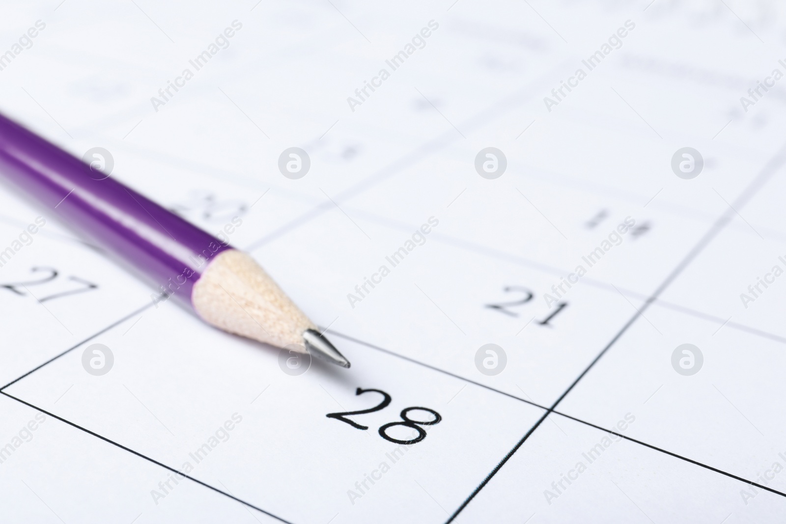 Photo of Pencil on calendar page, closeup. Planning concept