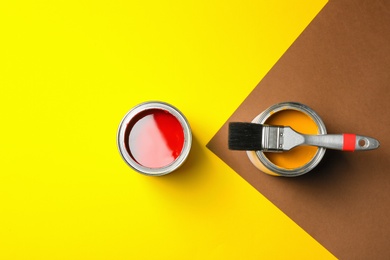 Photo of Flat lay composition with paint cans on color background