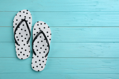 Stylish flip flops on light blue wooden background, flat lay. Space for text