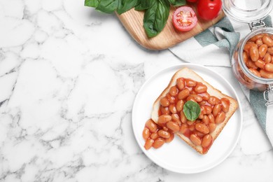Photo of Toast with delicious canned beans on white marble table, flat lay. Space for text