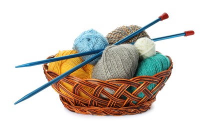 Photo of Wicker basket with different balls of woolen knitting yarns and needles on white background
