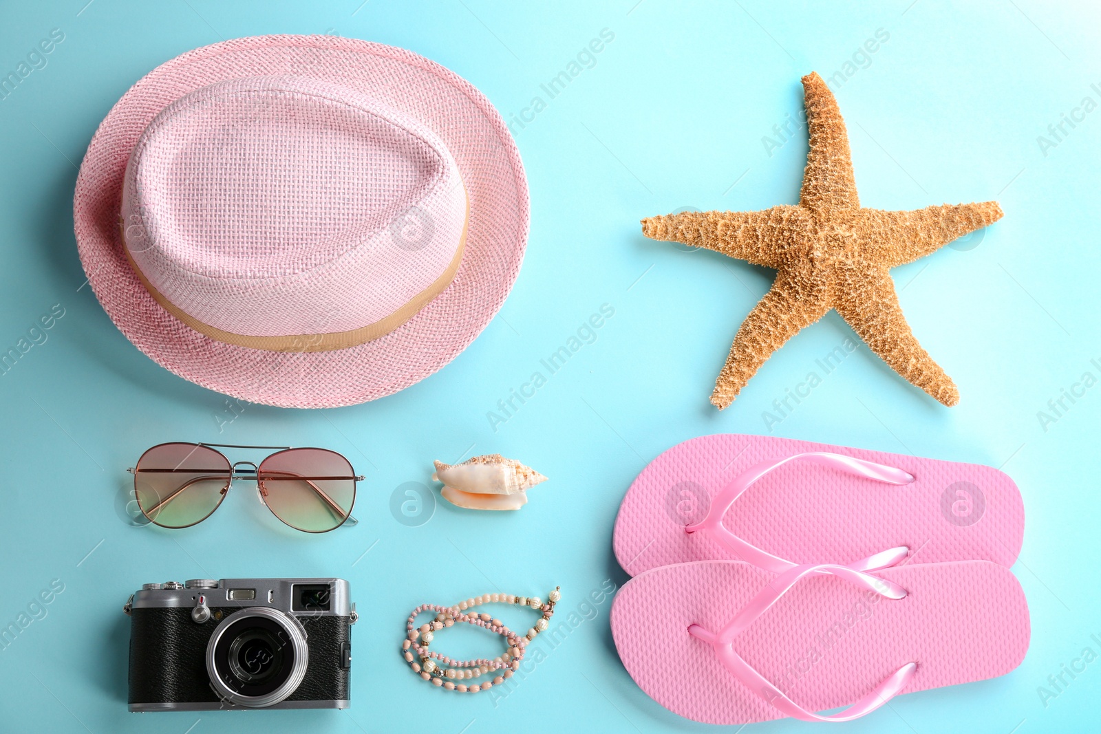 Photo of Flat lay composition with stylish hat, camera and beach objects on color background