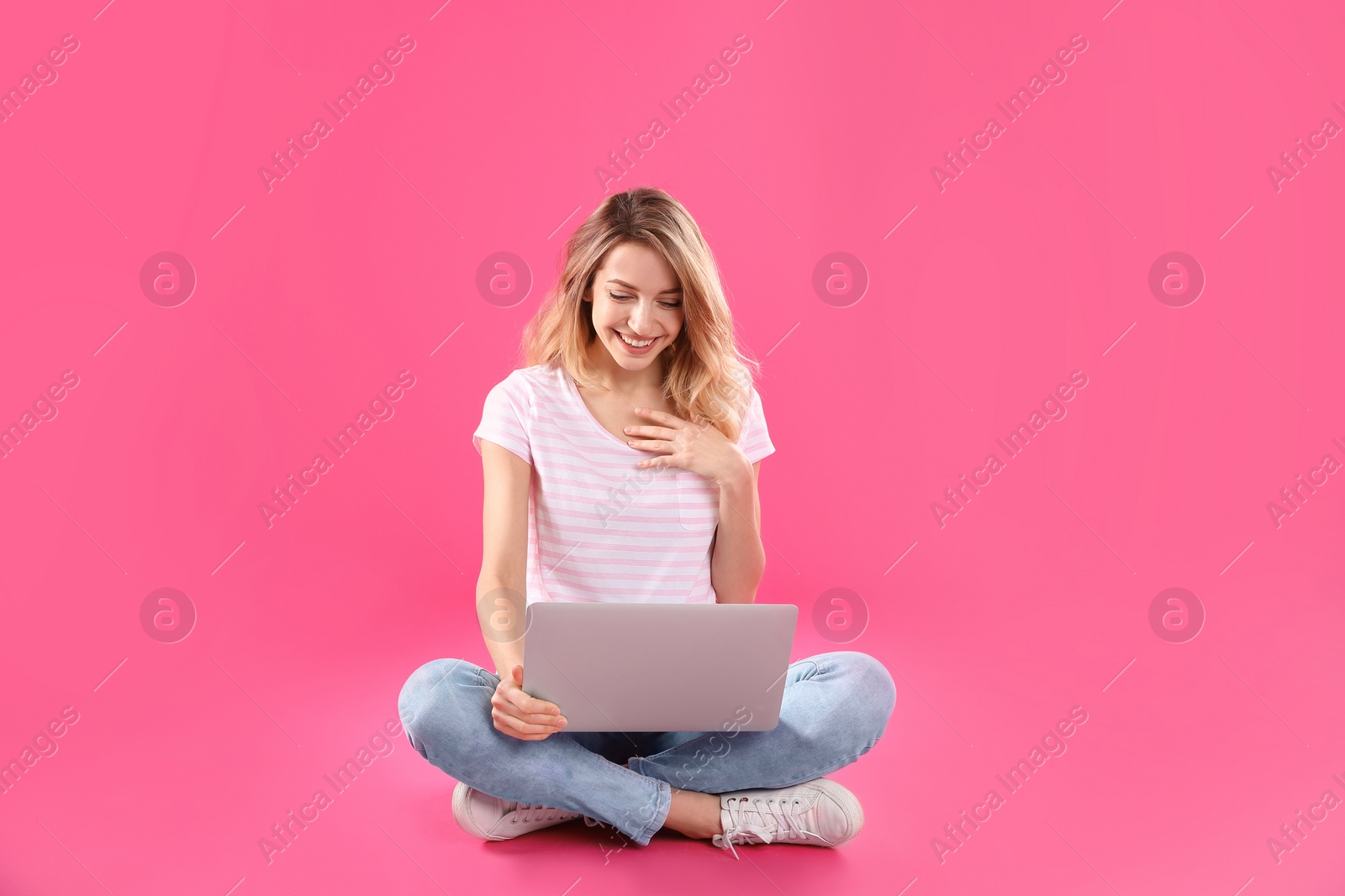 Photo of Woman using laptop for video chat on color background