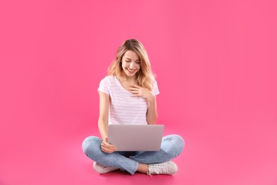 Woman using laptop for video chat on color background